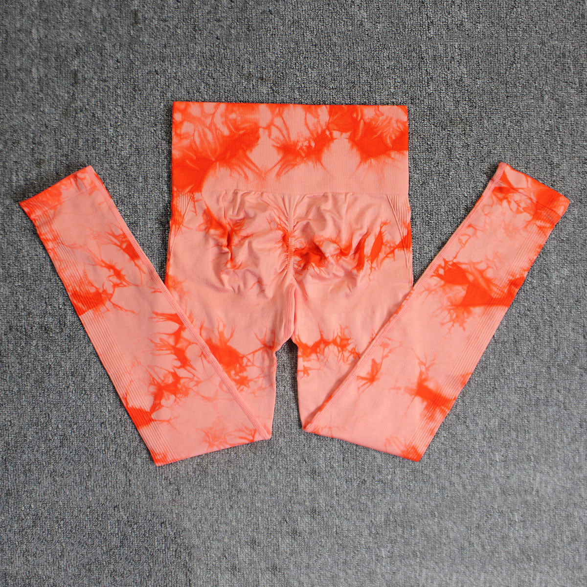 Vibrant seamless tie-dye yoga pants with high waist and peach hip lifting design. High-elastic compression leggings perfect for yoga and fitness.
